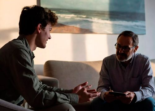 Молодой мужчина жестикулирует во время беседы с психотерапевтом